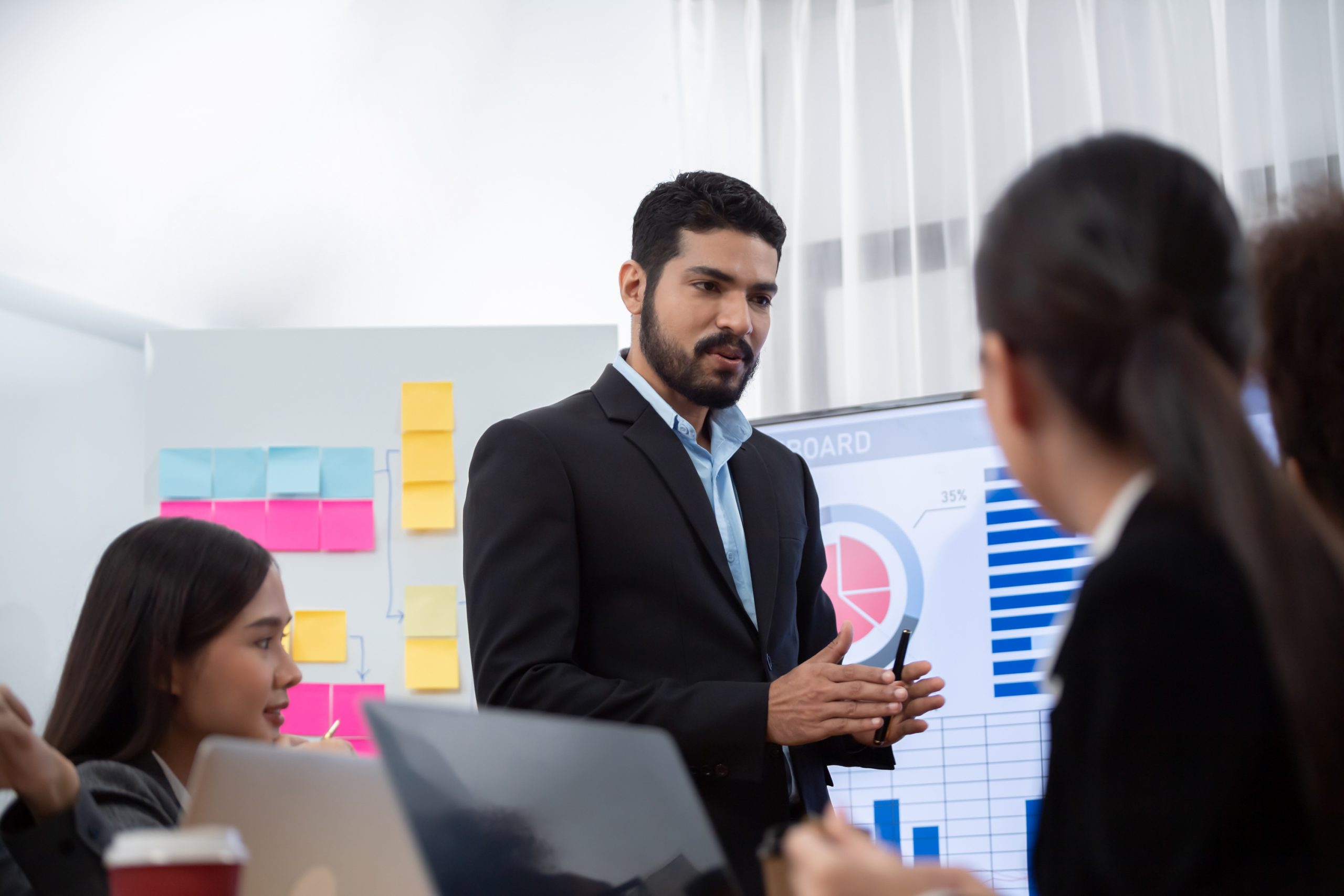 Businessman presenting data analysis dashboard display on TV screen in modern meeting for marketing strategy. Business presentation with group of business people in conference room. Concord